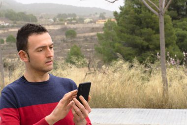 Akıllı telefon ekranı kullanan genç bir erkek. Kavram: Sosyal medya bağımlılığı.