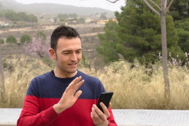 Orta yaşlı bir adam video konferansında sevgisini gösteriyor. Kavram: salgın zamanında güvenlik mesafesi.