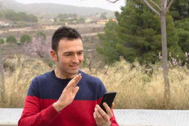 Orta yaşlı bir adam video konferansında sevgisini gösteriyor. Kavram: salgın zamanında güvenlik mesafesi.