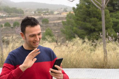 Orta yaşlı bir adam video konferansında sevgisini gösteriyor. Kavram: salgın zamanında güvenlik mesafesi.