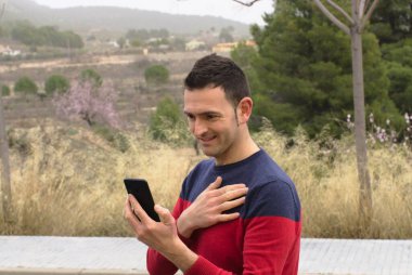 Orta yaşlı bir adam video konferansında sevgisini gösteriyor. Kavram: salgın zamanında güvenlik mesafesi.