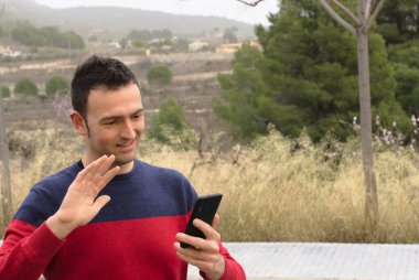 Orta yaşlı bir adam video konferansında sevgisini gösteriyor. Kavram: salgın zamanında güvenlik mesafesi.