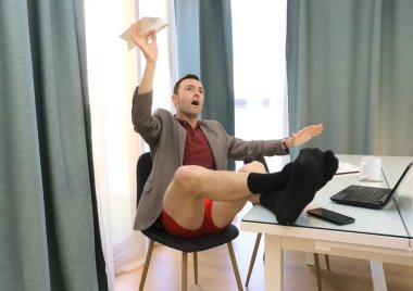 Evde çalışıyor olması gerekirken masa başında kağıt uçak uçuran mutlu aylak.