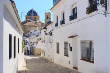 Altea, Alicante, İspanya - 3 Nisan 2021. Altea sokaklarındaki beyaz evlerin manzarası. Arka planda kilise var.