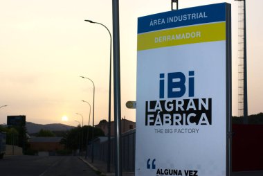 Ibi, Alicante, İspanya - Temmuz 2021. Ibi la gran kumaşının arkasında gün batımı, derramador. Büyük fabrika, sanayi illüstri editörü