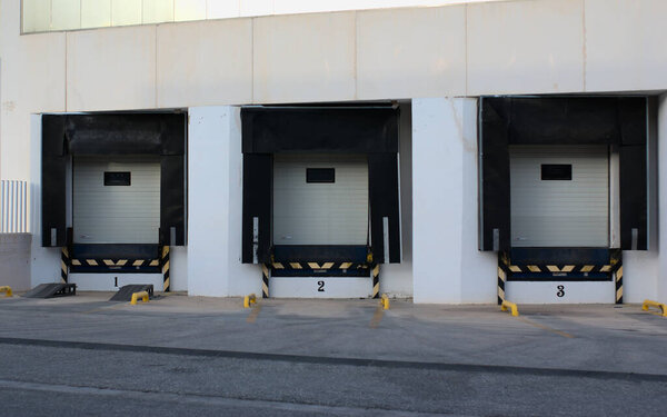 Ibi, Spain - July 2021. Facade of 3 loading dock ready to receive truck. Factory in industrial town. Editorial illustrative.