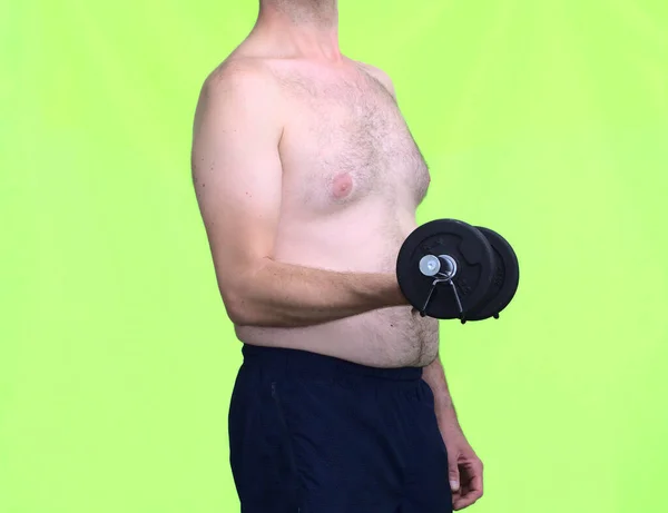 フィットを得るためにダンベルを持ち上げる投機を示す中年の白い脂肪の男 健康的な生活をコンセプト ストック画像
