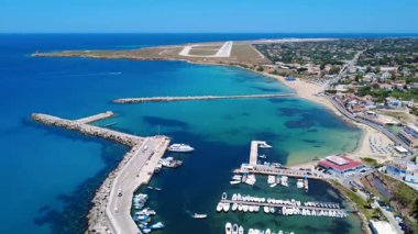 Kıyı kasabasında güneşli bir günde, kumsala yakın güzel bir limana yanaşan tekneler. Terrasini, Sicilya, İtalya