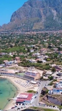 Açık Mavi Gök Altındaki Büyüleyici Sahil Kasabası 'nın yakınındaki Turkuaz Suları' nda süzülen bir yelkenlinin çarpıcı manzarası. Terrasini, Sicilya, İtalya