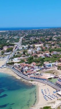 Açık Mavi Gök Altındaki Büyüleyici Sahil Kasabası 'nın yakınındaki Turkuaz Suları' nda süzülen bir yelkenlinin çarpıcı manzarası. Terrasini, Sicilya, İtalya