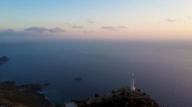 Sahilde gün doğumu Okyanusun üstünde Arka planda Dağlarla