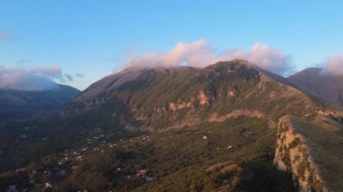 Gün batımında İtalya 'da Yeşil Tepeler ve Küçük Evlerle Bir Dağ Manzarası Keşfedin