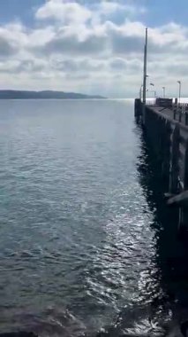 Bulutlu Gökyüzü ve Rıhtımın Yanındaki Dağlarla Suya Uzanan Bir İskele Manzarası. Starnberg, Almanya