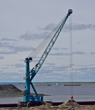 Liebherr vinci Dudinka limanındaki mavnalardan kum boşaltıyor.