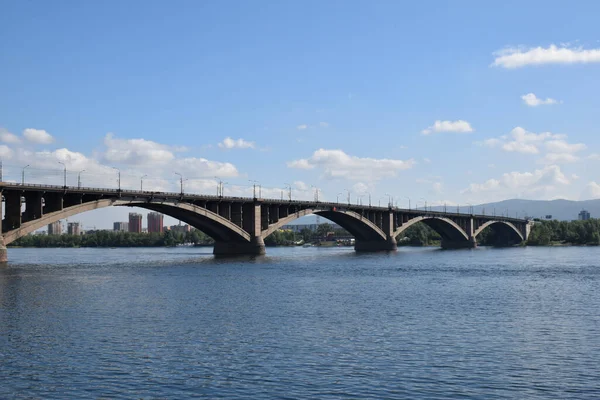 Yazın Krasnoyarsk şehrinde Yenisei Nehri ve Komün Köprüsü manzarası.