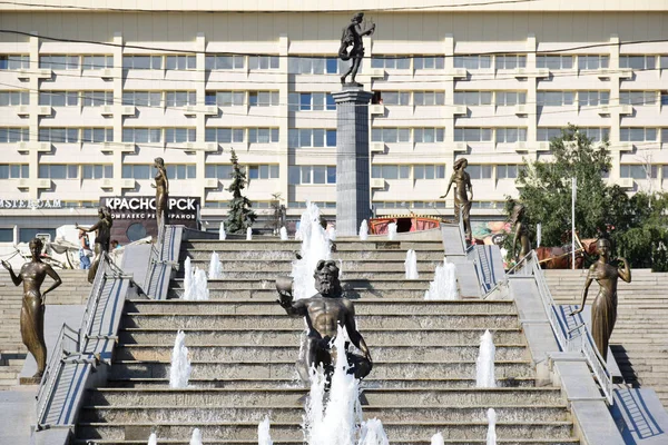 Yenisei, Khatanga, Angara, Mana, Bazaiha nehirlerini çevreleyen binaların arka planında tasvir eden heykellerle Krasnoyarsk şehir merkezindeki çağlayan çeşmenin fotoğrafı