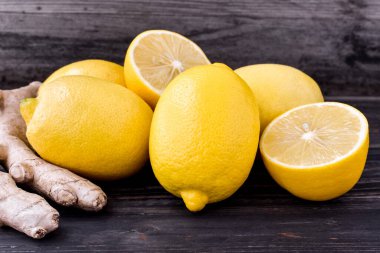 Limonlar, kırsal ve ahşap arka planda zencefil kökü. Kesim ve bütün turunçgiller..