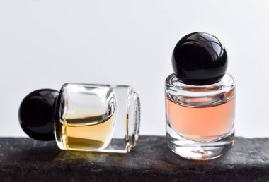 Şişede iki çeşit yağ esanslı parfüm, taş tezgahı, beyaz arka plan. Kapat..