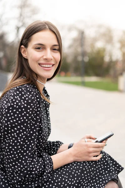 Encantadora Mujer Negocios Sonriente Sentada Afuera Sosteniendo Teléfono Móvil Mirando — Foto de Stock