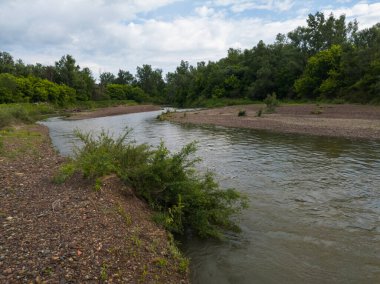 Zboriste 'deki Ukrina nehrinin manzarası, bulutlu bir yaz gününde, çakıl taşları ile kaplı kıyılar arasında hızlı su akıntıları kopuyor.