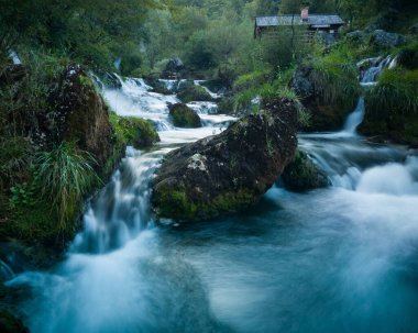 Bosna-Hersek 'in Banja luka kenti yakınlarındaki popüler turizm merkezi Krupa na Vrbasu' da büyük kayalar ve şelaleler bulunan Krupa nehri kıyısındaki küçük geleneksel ahşap su değirmeni..