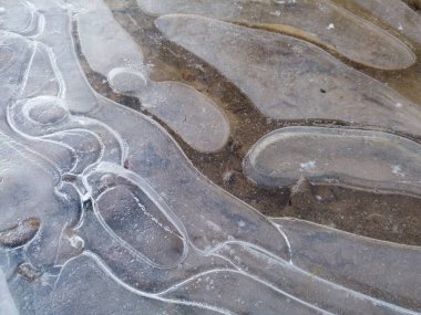 Kışın donmuş su birikintisi üzerinde buzda yuvarlak düzensiz şekiller, sertlik ve durgunluk kavramı