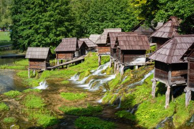 Pliva Gölü 'ndeki kutuplardaki küçük su değirmenleri, Jajce yakınlarındaki turizm beldesi.