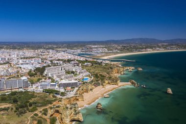 Lagos, Algarve, Portekiz 'deki Dona Ana Sahili. Portekiz 'in güneyindeki altın sahil kayalıkları. Arka planda şehir olan hava manzarası. Camilo ve pinhao plajı..