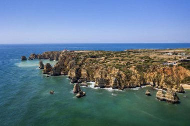 Ponta da Piedade deniz feneri. Portekiz 'in güneyindeki altın sahil kayalıkları. Portekiz, Algarve 'deki Lagos şehrinin hava manzarası. Turkuaz deniz. Camilo Sahili.