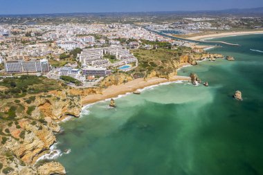 Lagos, Algarve, Portekiz 'deki Dona Ana Sahili. Portekiz 'in güneyindeki altın sahil kayalıkları. Arka planda şehir olan hava manzarası. Camilo ve pinhao plajı..