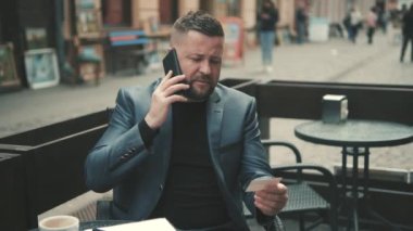 Güzel saç stili ve sakallı çekici yakışıklı adam. Modern akıllı telefonunu kullanıyor. Çok şık ve muhteşem görünüyorsun. Haki rengi tişört ve temel beyaz tişört giyiyordu. İletiler Yazılıyor.