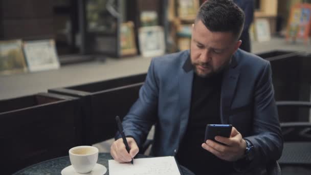 Zakenman Schrijft Berekeningen Een Stuk Papier — Stockvideo