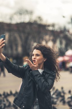 Sokaktaki güzel esmer telefonda konuşuyor..