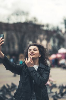 Sokaktaki güzel esmer telefonda konuşuyor..