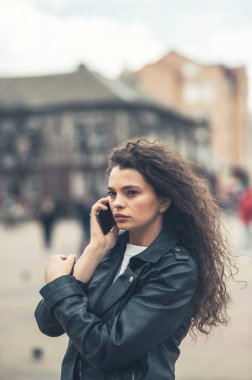Sokaktaki güzel esmer telefonda konuşuyor..