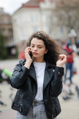 Güzel bir kadın telefonda konuşuyor.