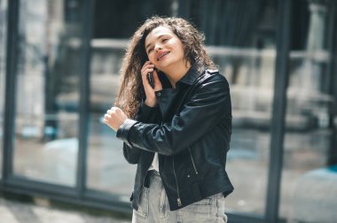 Yazın tren istasyonunda bekleyen bir kadın. Telefonda konuşan güzel bir kız. Cep telefonuyla konuşan genç bir kadın.