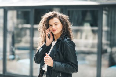 Yazın tren istasyonunda bekleyen bir kadın. Telefonda konuşan güzel bir kız. Cep telefonuyla konuşan genç bir kadın.