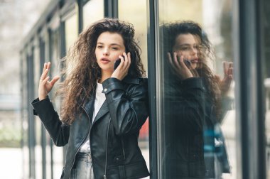 Yazın tren istasyonunda bekleyen bir kadın. Telefonda konuşan güzel bir kız. Cep telefonuyla konuşan genç bir kadın.