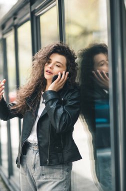 Yazın tren istasyonunda bekleyen bir kadın. Telefonda konuşan güzel bir kız. Cep telefonuyla konuşan genç bir kadın.