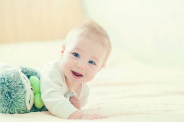 Yatakta oynayan neşeli çocuk..