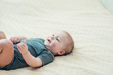 Yatakta oynayan neşeli çocuk..