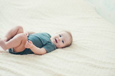 Yatakta oynayan neşeli çocuk..