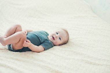 Yatakta oynayan neşeli çocuk..