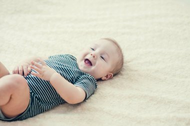 Yatakta oynayan neşeli çocuk..