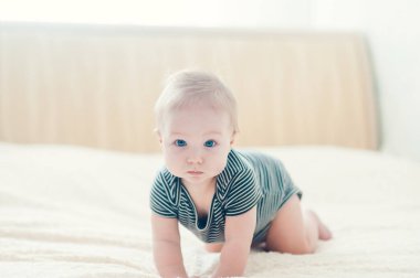 Yatakta oynayan neşeli çocuk..