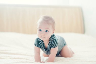 Yatakta oynayan neşeli çocuk..