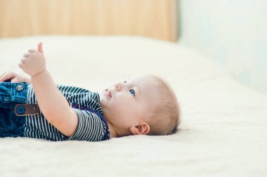 Yatakta oynayan neşeli çocuk..