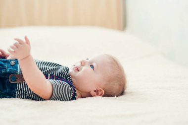 Yatakta oynayan neşeli çocuk..