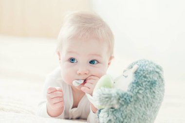 Yakışıklı, neşeli çocuk yatakta emekliyor..